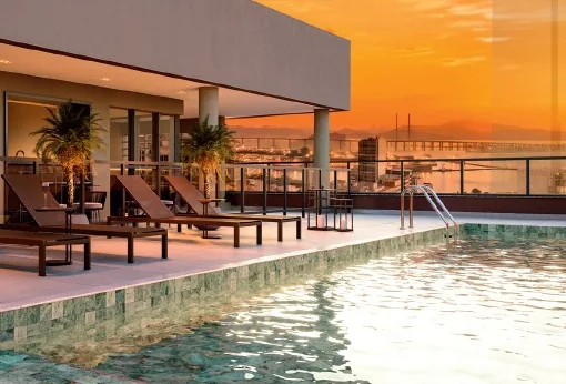 Piscina do Q Studios ao entardecer com vista para a Baía de Guanabara